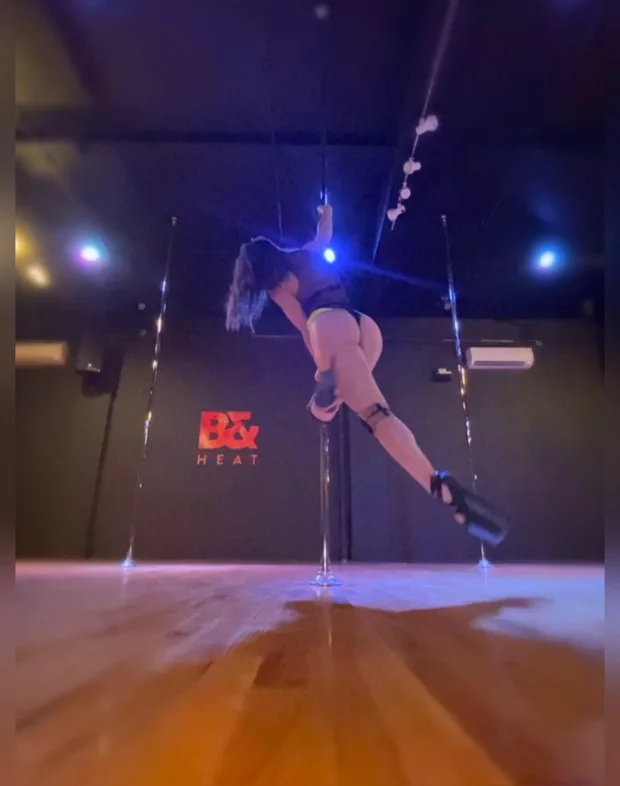 Polina Zueva inverted on the pole under blue studio light, from Exotic Choreography 5.